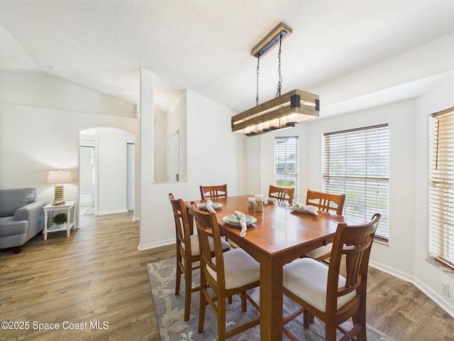 187 S Wimbrow Dr, Sebastian, FL 32958 - dining area featuring arched walkways, wood finished floors, baseboards, and vaulted ceiling