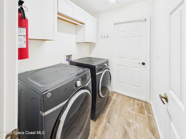 187 S Wimbrow Dr, Sebastian, FL 32958 - washroom with cabinet space, washing machine and clothes dryer, and light wood-style flooring