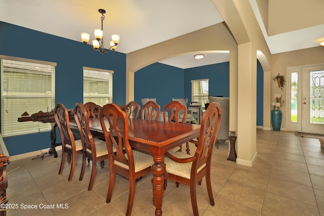 1403 Musgrass Cir, West Melbourne, FL 32904 - tiled dining space featuring arched walkways, a chandelier, and plenty of natural light
