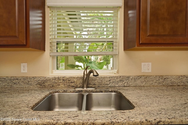 1403 Musgrass Cir, West Melbourne, FL 32904 - kitchen view of a sink, light stone counters, and brown cabinets