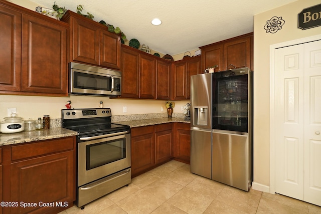 1403 Musgrass Cir, West Melbourne, FL 32904 - kitchen with stainless steel appliances, light tile patterned floors, stone counters, a textured ceiling, and recessed lighting
