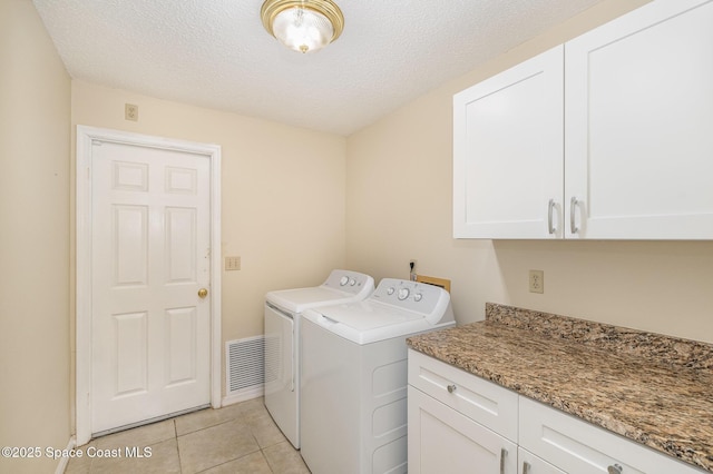 3137 Village Park Dr, Melbourne, FL 32934 - laundry room with cabinet space, washing machine and clothes dryer, light tile patterned floors, and a textured ceiling