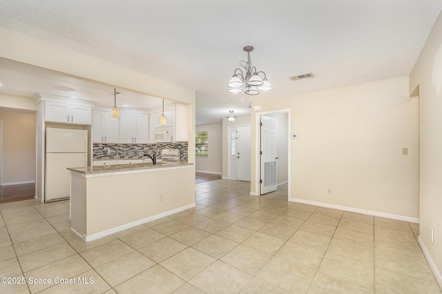 3137 Village Park Dr, Melbourne, FL 32934 - kitchen with white appliances, backsplash, a chandelier, white cabinetry, and light tile patterned floors