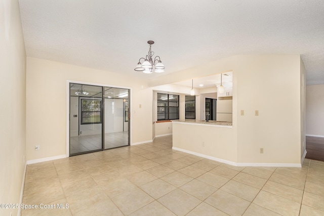 3137 Village Park Dr, Melbourne, FL 32934 - empty room with light tile patterned floors, a chandelier, and baseboards
