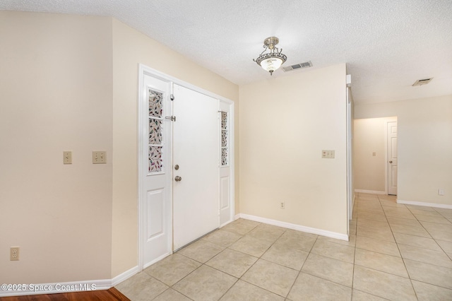 3137 Village Park Dr, Melbourne, FL 32934 - foyer with a textured ceiling, light tile patterned floors, and baseboards