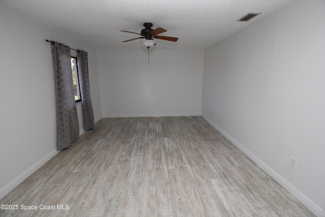 217 San Juan Cir, Melbourne, FL 32935 - empty room with a ceiling fan, wood finished floors, a textured ceiling, and baseboards