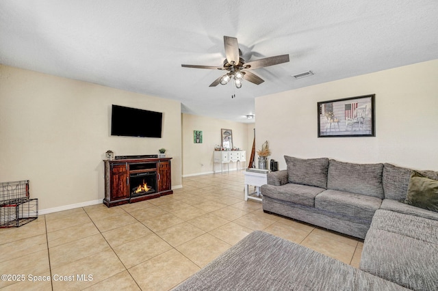 946 Stage St SE, Palm Bay, FL 32909 - living area featuring ceiling fan, light tile patterned floors, baseboards, and a warm lit fireplace