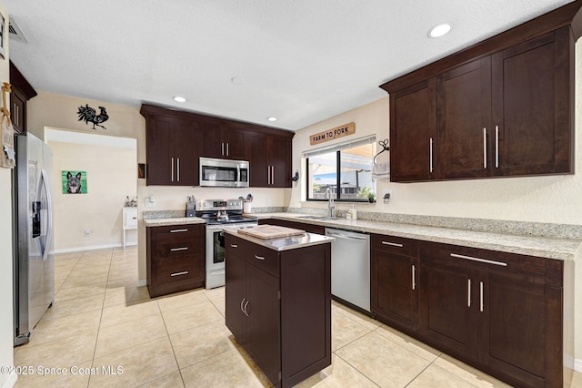 946 Stage St SE, Palm Bay, FL 32909 - kitchen featuring stainless steel appliances, a kitchen island, light countertops, light tile patterned flooring, and recessed lighting