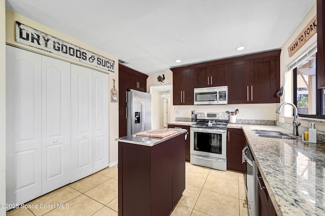 946 Stage St SE, Palm Bay, FL 32909 - kitchen featuring stainless steel appliances, a sink, a kitchen island, light stone counters, and recessed lighting