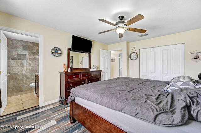946 Stage St SE, Palm Bay, FL 32909 - bedroom with a closet, ceiling fan, ensuite bath, baseboards, and wood finished floors