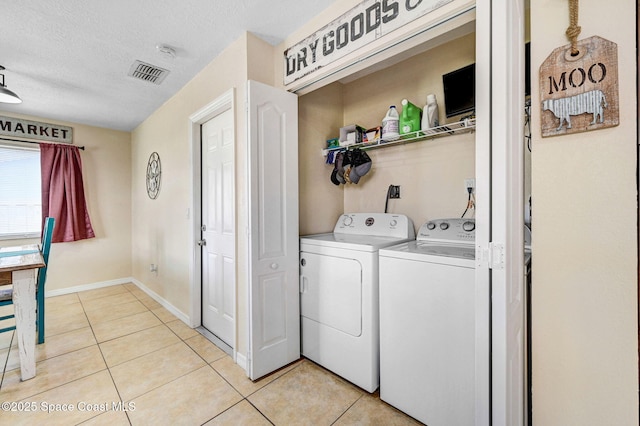 946 Stage St SE, Palm Bay, FL 32909 - laundry room with independent washer and dryer, light tile patterned floors, a textured ceiling, and baseboards