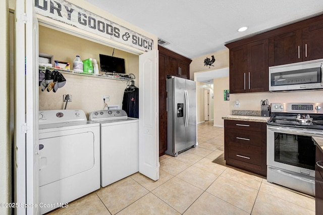 946 Stage St SE, Palm Bay, FL 32909 - kitchen featuring stainless steel appliances, separate washer and dryer, dark brown cabinets, light tile patterned floors, and recessed lighting