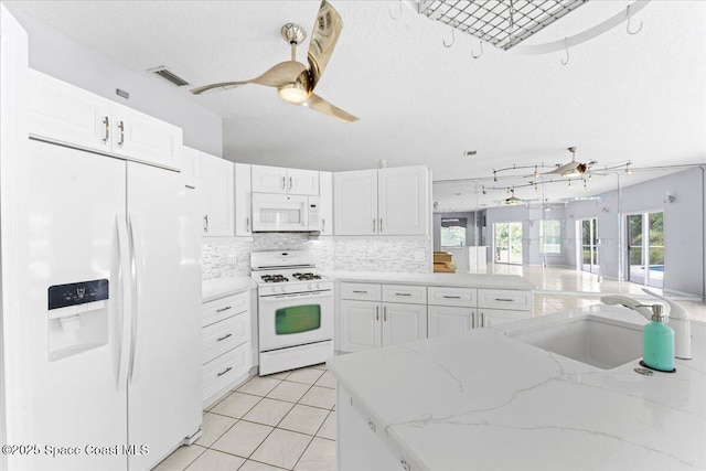 990 Harbor Pines Dr, Merritt Island, FL 32952 - kitchen featuring white appliances, a sink, white cabinetry, ceiling fan, and a textured ceiling