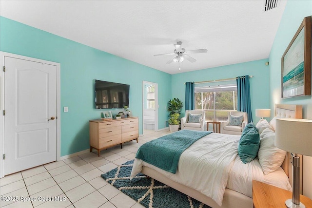 990 Harbor Pines Dr, Merritt Island, FL 32952 - bedroom featuring light tile patterned floors, baseboards, ceiling fan, connected bathroom, and a textured ceiling