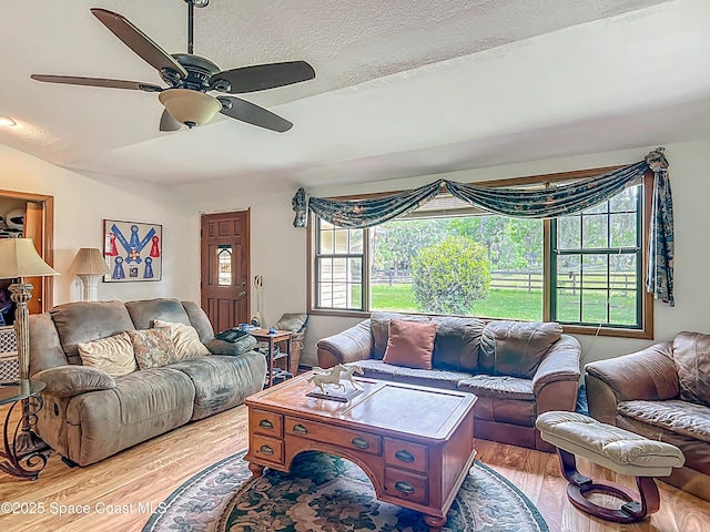 750 SW 91st Pl, Ocala, FL 34476 - living room featuring wood finished floors, a ceiling fan, and a textured ceiling