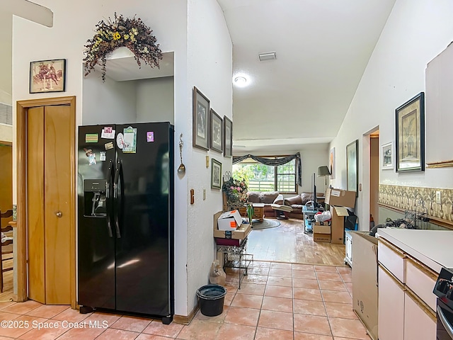 750 SW 91st Pl, Ocala, FL 34476 - kitchen with black fridge, light tile patterned floors, open floor plan, light countertops, and stove