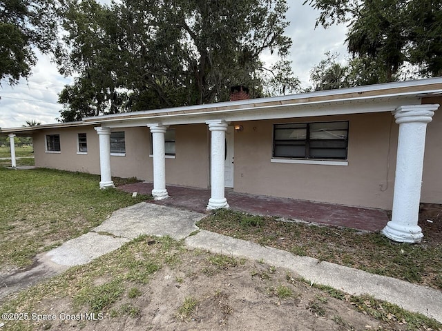 600 Byron Ave, Daytona Beach, FL 32114 - greek revival inspired property with stucco siding, a chimney, and a front lawn