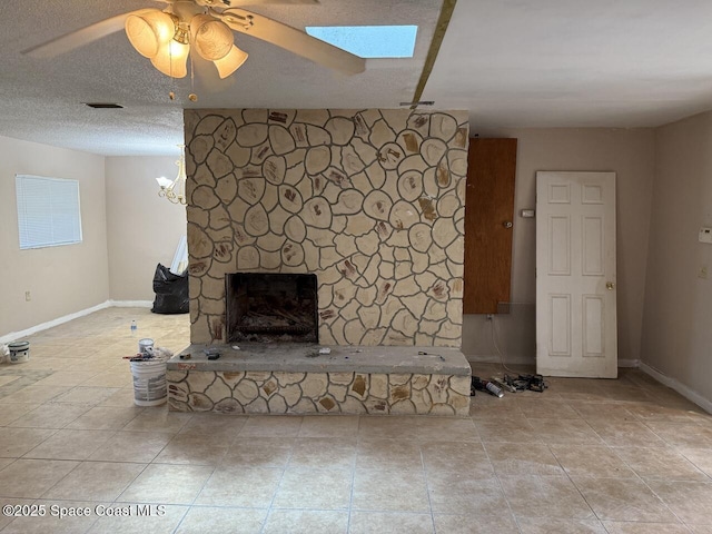 600 Byron Ave, Daytona Beach, FL 32114 - unfurnished living room featuring a fireplace, a ceiling fan, baseboards, and a skylight