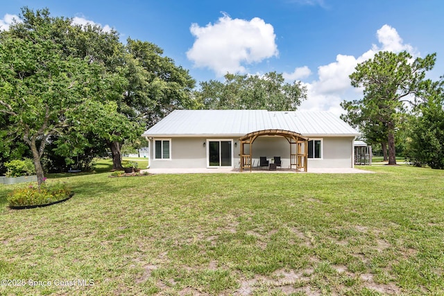 4027 Secretariat Ln, Malabar, FL 32950 - rear view of house with stucco siding, a patio, a yard, and metal roof