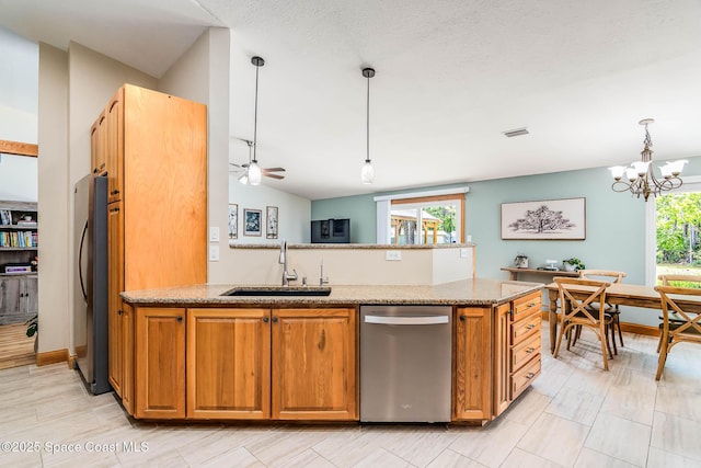 4027 Secretariat Ln, Malabar, FL 32950 - kitchen with stainless steel appliances, a sink, brown cabinets, and hanging light fixtures