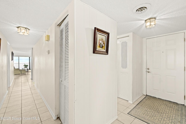 3170 N Atlantic Ave Unit 407, Cocoa Beach, FL 32931 - entrance foyer featuring light tile patterned flooring, a textured ceiling, and baseboards