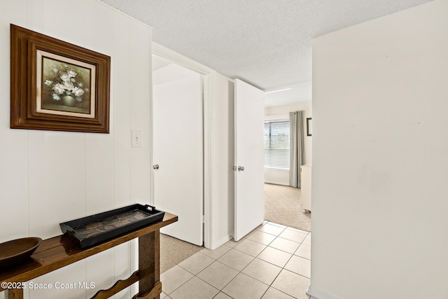 3170 N Atlantic Ave Unit 407, Cocoa Beach, FL 32931 - hall with light carpet, a textured ceiling, light tile patterned flooring, and baseboards
