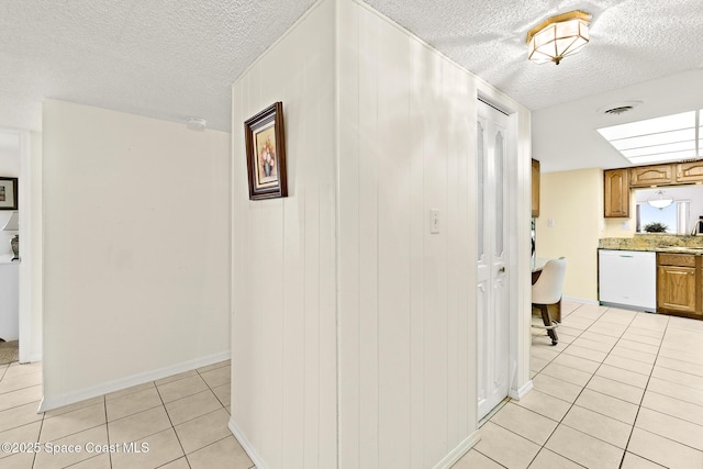 3170 N Atlantic Ave Unit 407, Cocoa Beach, FL 32931 - hallway featuring light tile patterned floors, a textured ceiling, baseboards, and a sink