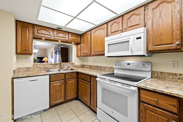 3170 N Atlantic Ave Unit 407, Cocoa Beach, FL 32931 - kitchen featuring white appliances, a sink, brown cabinetry, and light tile patterned floors