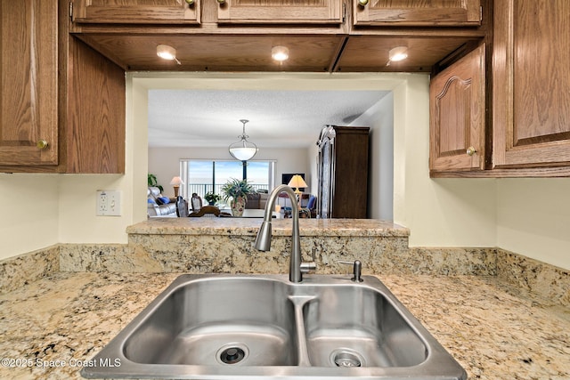 3170 N Atlantic Ave Unit 407, Cocoa Beach, FL 32931 - kitchen view of a sink, light stone counters, and brown cabinets