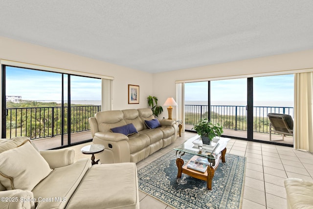 3170 N Atlantic Ave Unit 407, Cocoa Beach, FL 32931 - living area with a water view, light tile patterned flooring, and a textured ceiling
