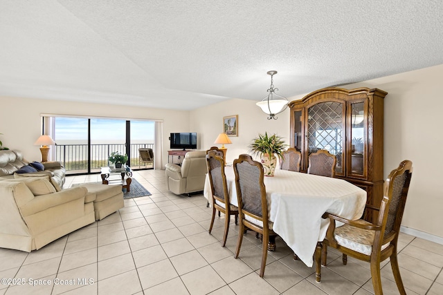 3170 N Atlantic Ave Unit 407, Cocoa Beach, FL 32931 - dining area featuring light tile patterned flooring and a textured ceiling