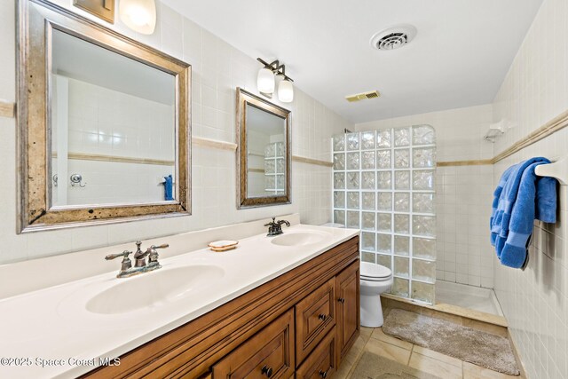 3170 N Atlantic Ave Unit 407, Cocoa Beach, FL 32931 - full bath with tile walls, double vanity, a walk in shower, toilet, and tile patterned flooring