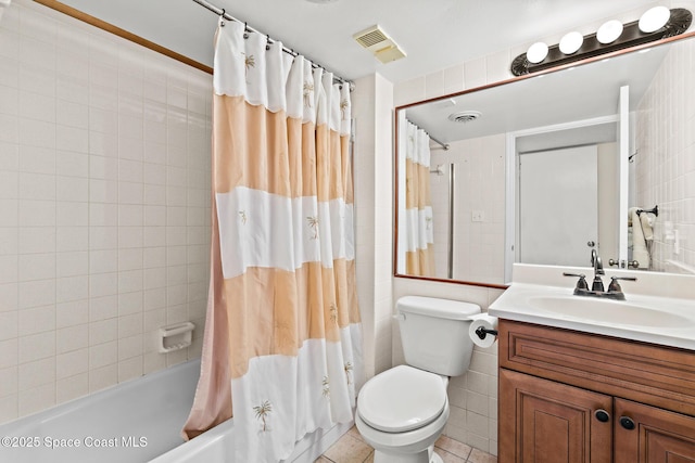 3170 N Atlantic Ave Unit 407, Cocoa Beach, FL 32931 - full bathroom with shower / bath combo with shower curtain, vanity, toilet, tile walls, and tile patterned flooring