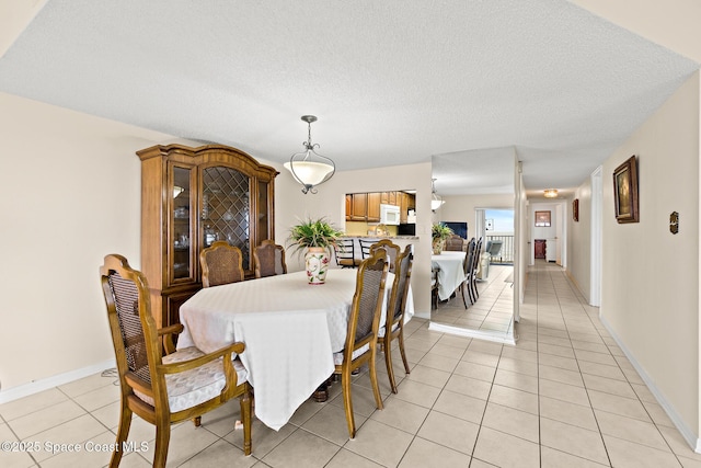 3170 N Atlantic Ave Unit 407, Cocoa Beach, FL 32931 - dining area featuring light tile patterned floors, a textured ceiling, and baseboards