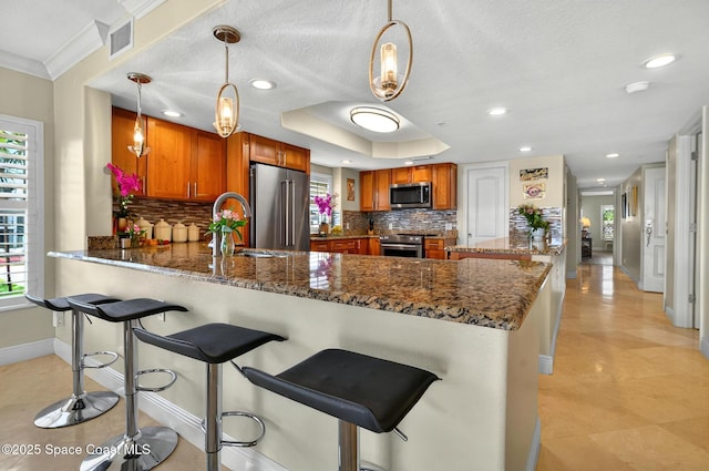 211 S 24th St Unit 202, Cocoa Beach, FL 32931 - kitchen featuring high quality appliances, a peninsula, plenty of natural light, ornamental molding, and a textured ceiling