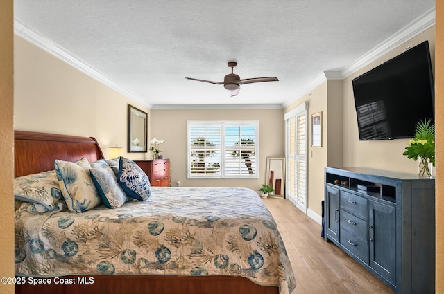 211 S 24th St Unit 202, Cocoa Beach, FL 32931 - bedroom with light wood-style flooring, ornamental molding, a textured ceiling, ceiling fan, and baseboards