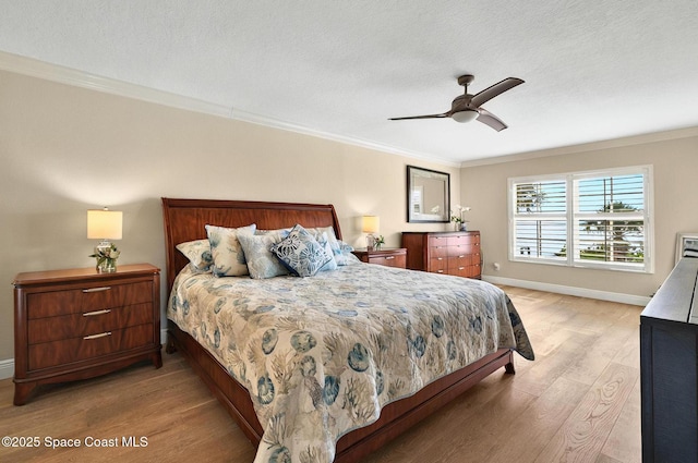 211 S 24th St Unit 202, Cocoa Beach, FL 32931 - bedroom with light wood-type flooring, crown molding, a textured ceiling, baseboards, and ceiling fan