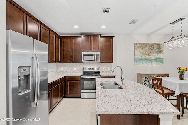 1415 Lara Cir Unit 105, Rockledge, FL 32955 - kitchen with appliances with stainless steel finishes, a sink, an island with sink, light stone counters, and recessed lighting