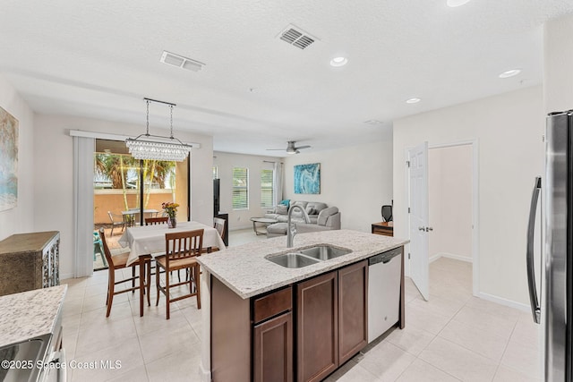 1415 Lara Cir Unit 105, Rockledge, FL 32955 - kitchen featuring stainless steel appliances, a sink, light tile patterned flooring, decorative light fixtures, and a kitchen island with sink