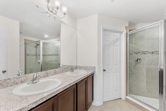 1415 Lara Cir Unit 105, Rockledge, FL 32955 - full bath featuring double vanity, a stall shower, tile patterned flooring, a textured ceiling, and a chandelier