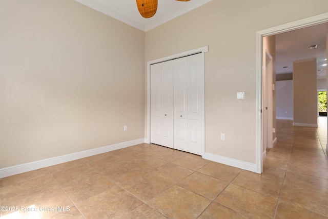 3140 Constellation Dr, Melbourne, FL 32940 - unfurnished bedroom featuring light tile patterned floors, a closet, baseboards, and crown molding