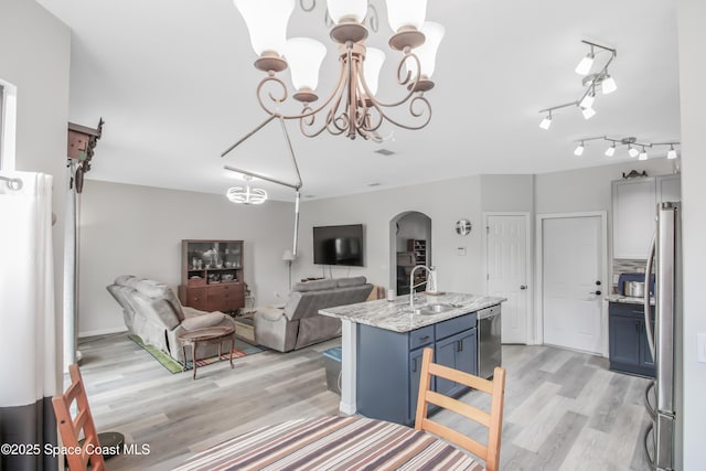 4345 Millicent Cir, Melbourne, FL 32901 - kitchen featuring a sink, arched walkways, stainless steel appliances, blue cabinets, and a chandelier