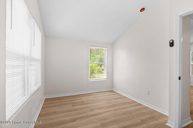 2295 Wood St, Melbourne, FL 32904 - unfurnished bedroom featuring light wood finished floors, lofted ceiling, and baseboards