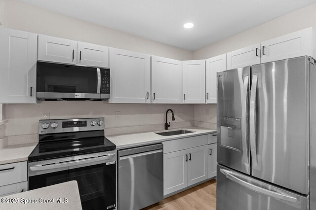 2295 Wood St, Melbourne, FL 32904 - kitchen with appliances with stainless steel finishes, a sink, light countertops, white cabinets, and recessed lighting
