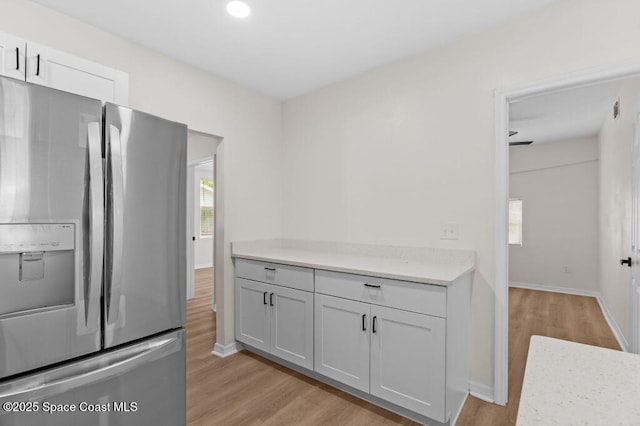 2295 Wood St, Melbourne, FL 32904 - kitchen with stainless steel refrigerator with ice dispenser, light wood finished floors, light countertops, baseboards, and recessed lighting