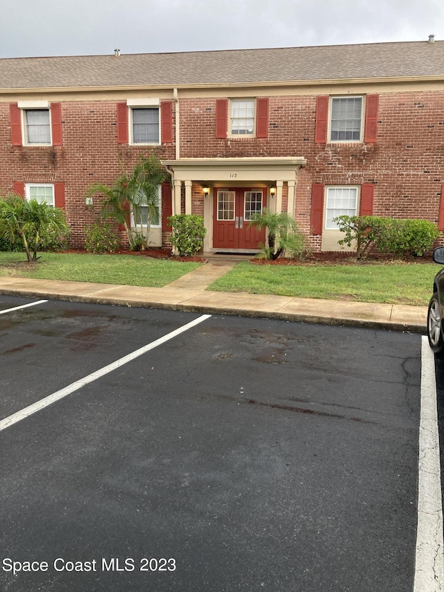 115 E Colonial Ct Unit C, Indian Harbour Beach, FL 32937 - view of property featuring brick siding and uncovered parking