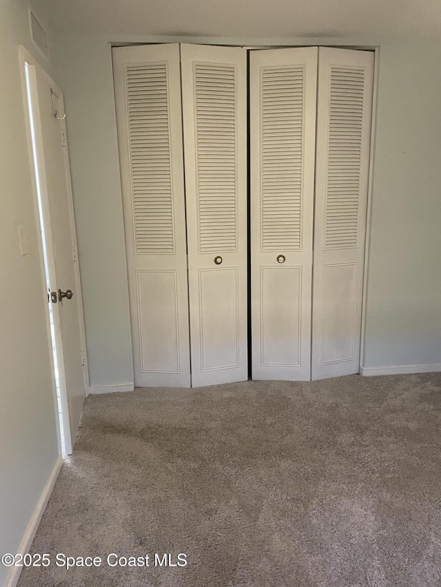 115 E Colonial Ct Unit C, Indian Harbour Beach, FL 32937 - unfurnished bedroom featuring carpet flooring, a closet, and baseboards
