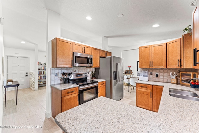 740 Hunan St NE, Palm Bay, FL 32907 - kitchen with stainless steel appliances, backsplash, brown cabinetry, recessed lighting, and a textured ceiling