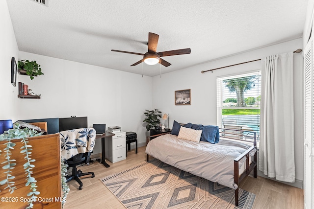 740 Hunan St NE, Palm Bay, FL 32907 - bedroom with an office area, light wood-style flooring, a textured ceiling, and a ceiling fan