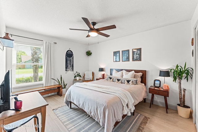 740 Hunan St NE, Palm Bay, FL 32907 - bedroom with light wood-style flooring, a textured ceiling, and a ceiling fan
